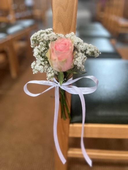 Bloemdecoratie aan een stoel tijdens de ceremonie